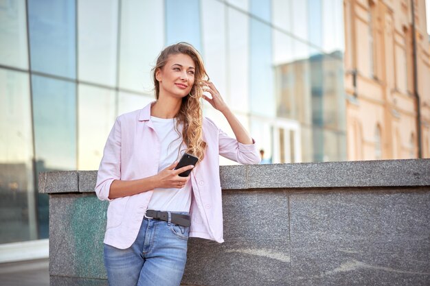 企業の建物の近くに立っている女性実業家ビジネスパーソン