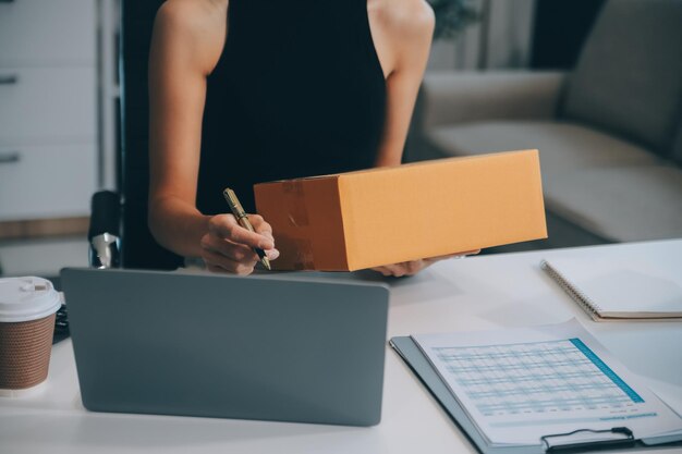 アジアの女性小規模企業を立ち上げ成功した中小企業起業家アジアの女性ホーディングボックス自宅からパッケージを配達オンライン配達中小企業配達コンセプトと包装