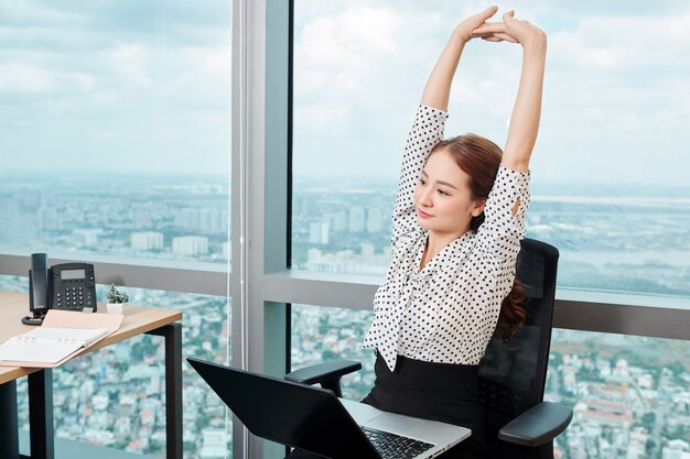 Businesswoman stretching in her chair