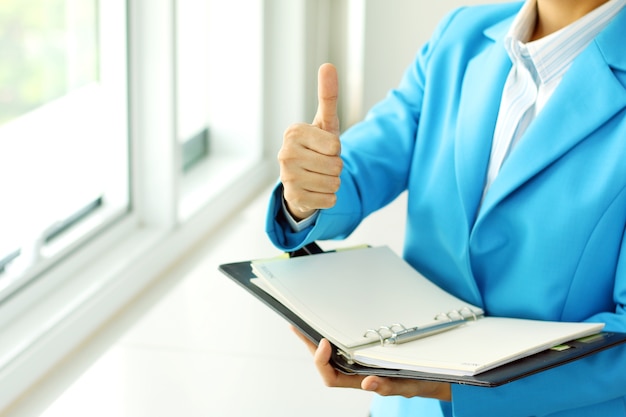 businesswoman in suit lifts his hand make the superb sign