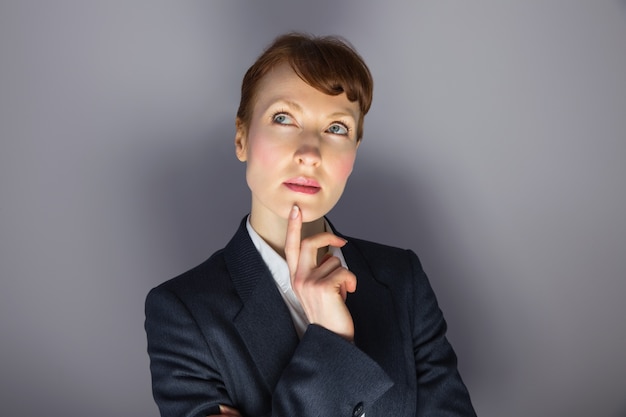 Businesswoman in suit thinking with finger on chin