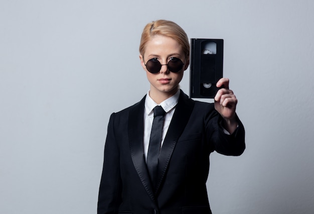 Businesswoman in sunglasses with video tape