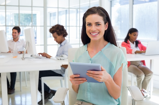 Businesswoman on tablet pc smiling at camera