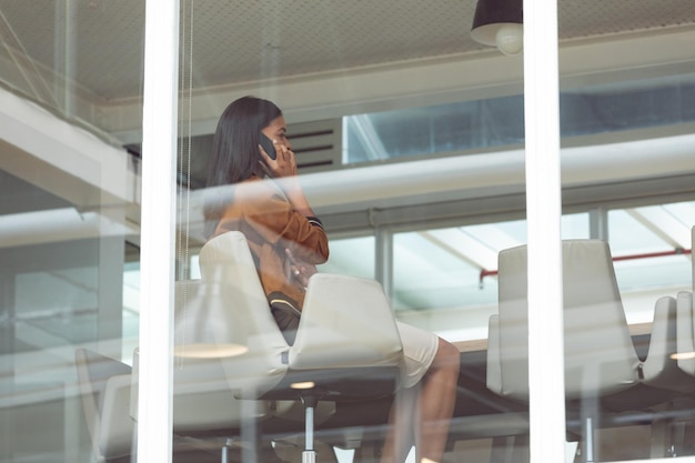 Photo businesswoman talking on mobile phone in a modern office