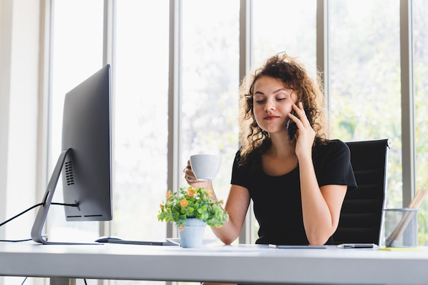 Photo businesswoman talking on mobile phone in office