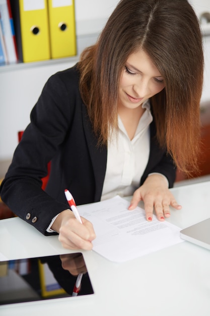 Businesswoman talking to mobile and working in office with laptop