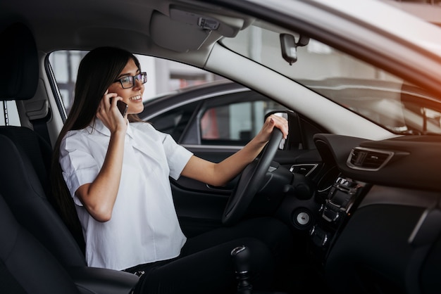 Businesswoman talking on the phone in car.