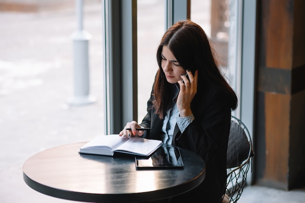 Businesswoman talking on the phone and taking notes