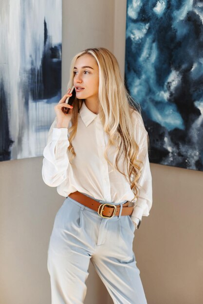 Businesswoman talking on the phone with a client in an art gallery