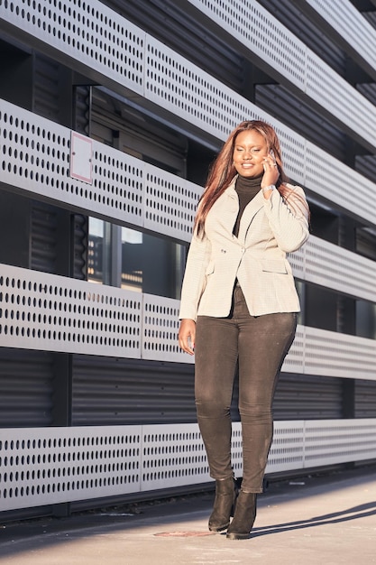 Businesswoman talking on smartphone African american woman in white plaid