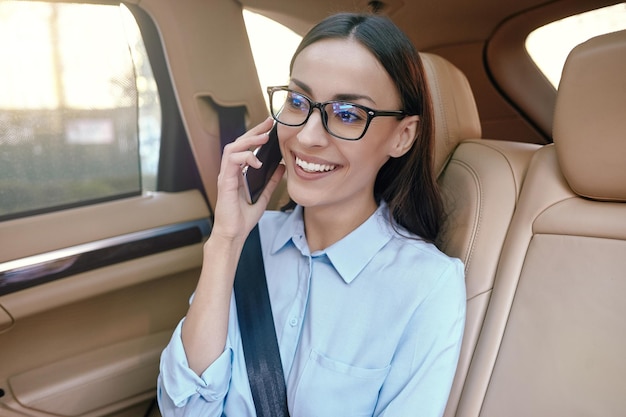 Businesswoman talking on smartphone in the car