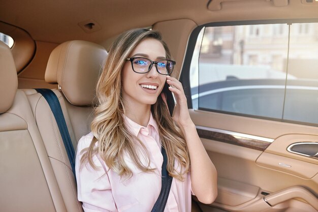 Businesswoman talking on smartphone in the car