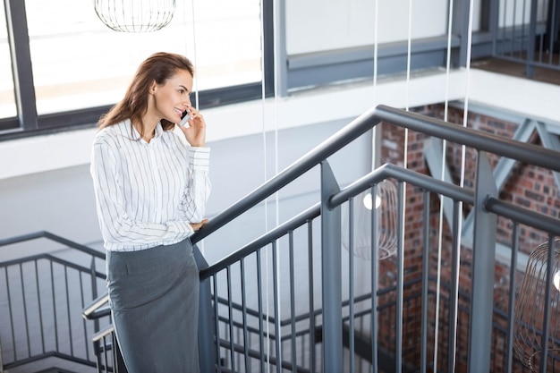 Businesswoman talking on smartphone in office