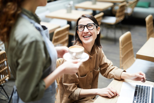 Businesswoman talking to waitress in cafe