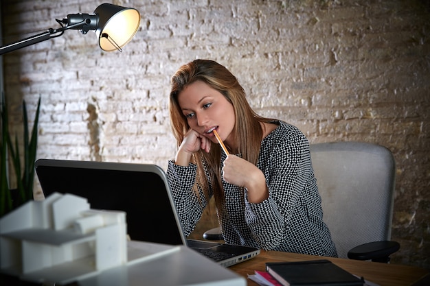 Businesswoman thinking with pencil in mouth