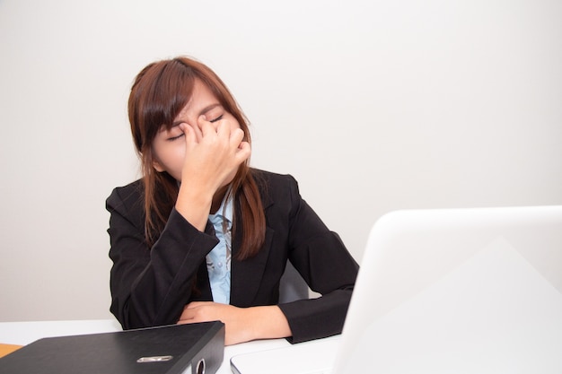 Businesswoman touching her eyes with eyes pain