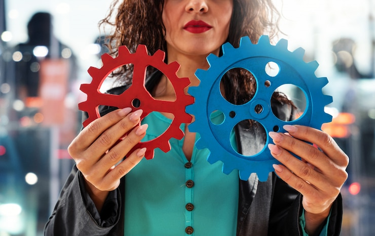 Photo businesswoman tries to work with gears. concept of teamwork and partnership.