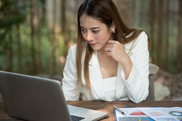 Businesswoman typing document on laptop computer.