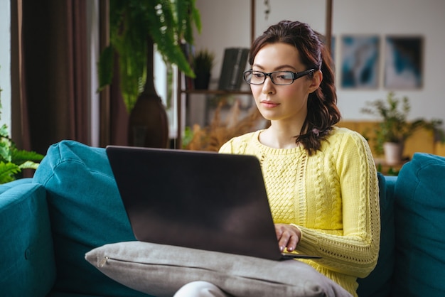 Businesswoman typing an email on laptop at home office