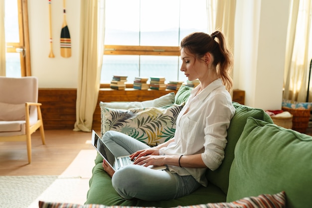 Businesswoman typing an email on laptop at home office