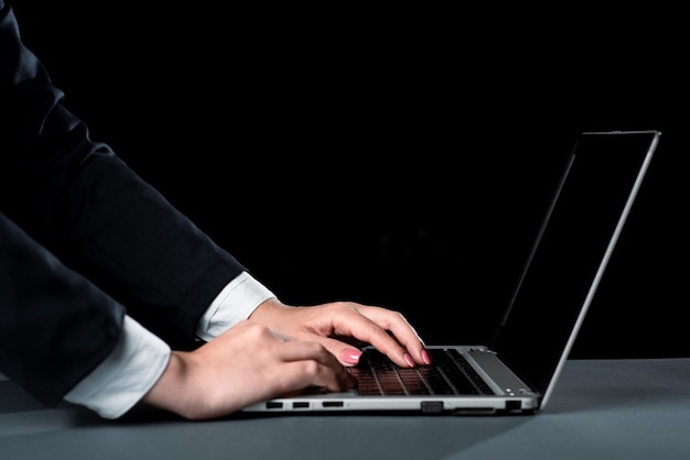 Businesswoman typing recent updates on lap top keyboard on desk woman in office writing important