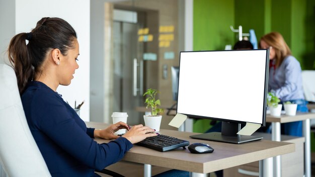 Businesswoman typing something on computer and look to screen