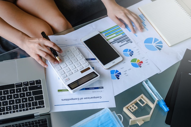 Businesswoman using calculator and laptop