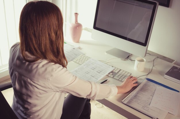 Photo businesswoman using computer at desk in office