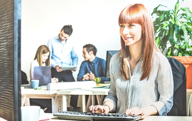 Foto donna d'affari che usa il computer con i colleghi in ufficio