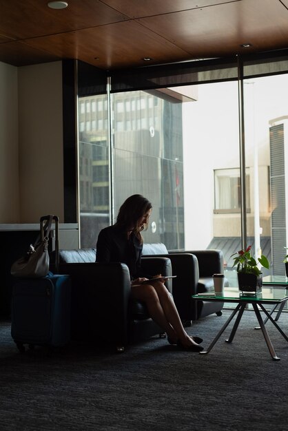 Businesswoman using digital tablet in the lobby of hotel