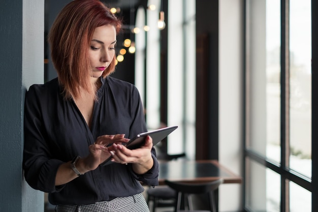 Foto donna d'affari che usa il tablet digitale mentre lavora in ufficio