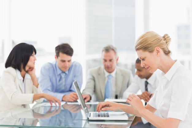 Businesswoman using her laptop during a meeting