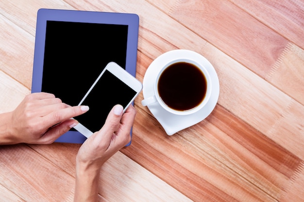 Businesswoman using her smartphone on desk