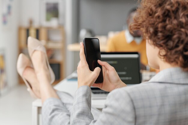 Businesswoman using her smartphone at office