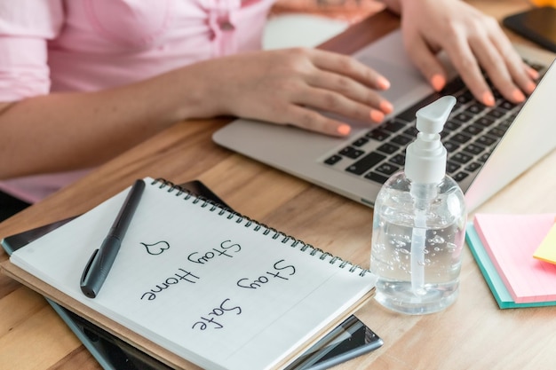 Photo businesswoman using laptop by spiral notebook at desk