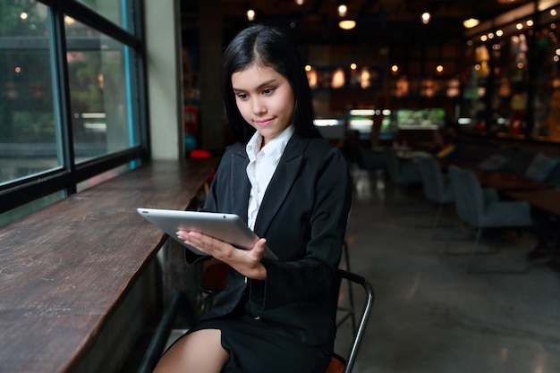 Donna di affari che utilizza computer portatile sulla tavola nel caffè