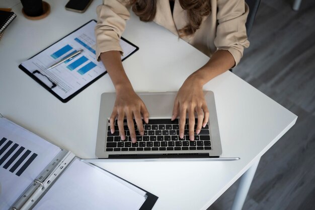 Businesswoman using laptop computer on white office desk