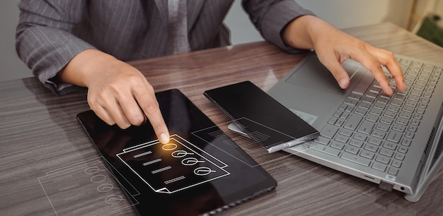 Businesswoman using a laptop and touching on virtual screen contact questionnaire with checkboxes