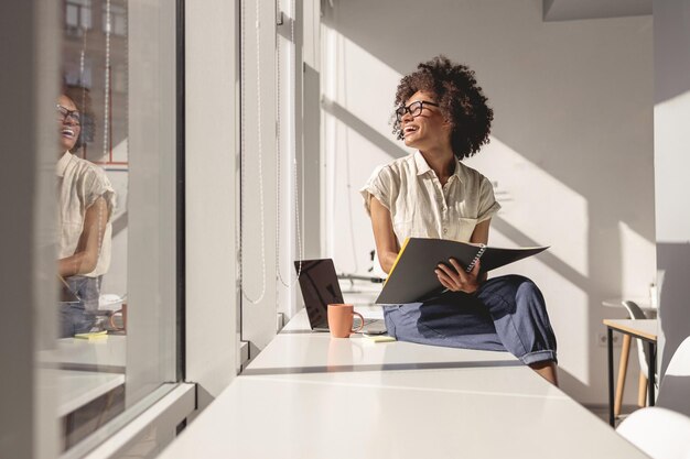 Photo businesswoman using laptop while sitting on table