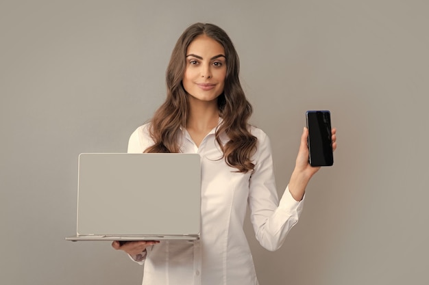 Деловая женщина с мобильным телефоном и ноутбуком Женщина показывает пустой экран ноутбука макет шаблона с копией пространства