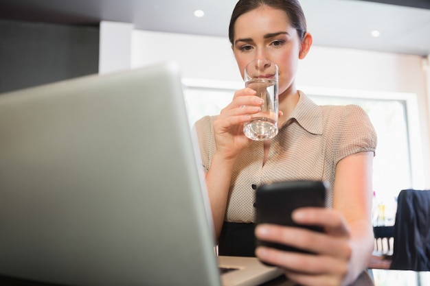 Businesswoman using phone in a cafe