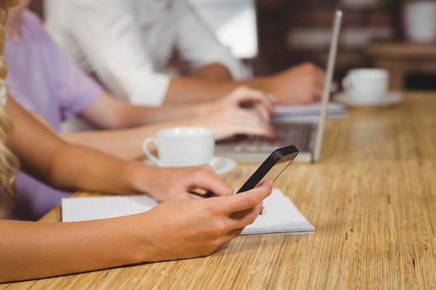 Businesswoman using phone at desk 