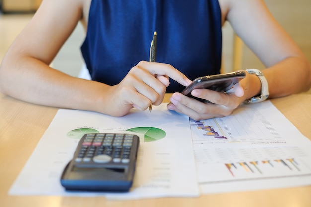 Businesswoman using smart phone for analysis maketing plan