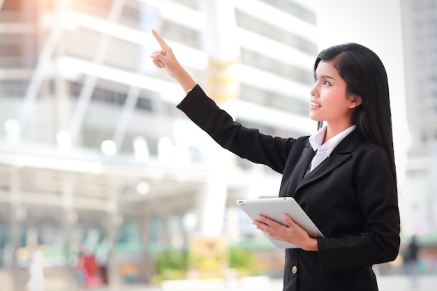 Businesswoman using tablet and pointing fingure