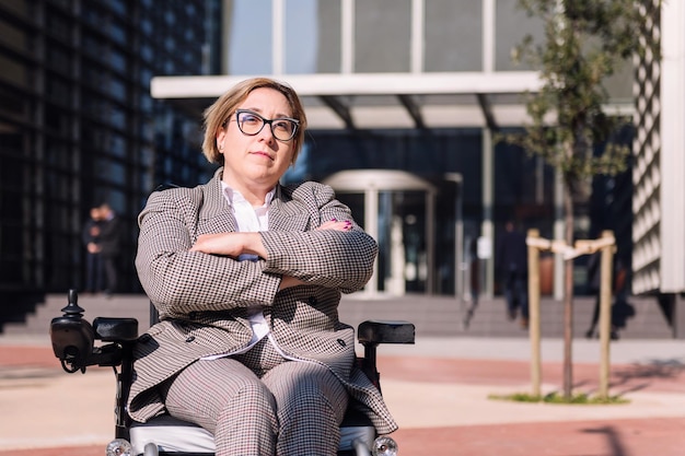 Businesswoman using wheelchair with arms crossed