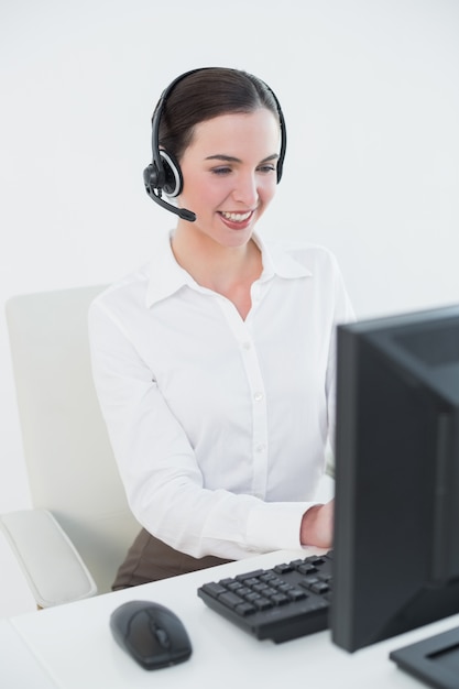 Foto donna di affari che indossa cuffia mentre si utilizza il computer