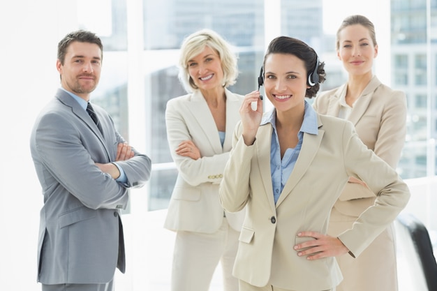 Businesswoman wearing headset with colleagues in office