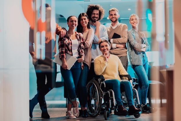 businesswoman in a wheelchair on break in a modern office with her team in the background