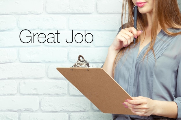 Businesswoman with clipboard and pen making notes and standing near text