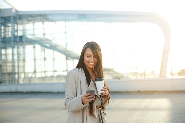 Imprenditrice con un caffè e un telefono